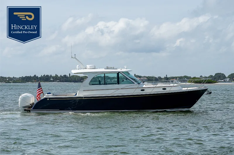 The Image of 2023 Hinckley Sport Boat 40 X on calm water with an American flag. - 0