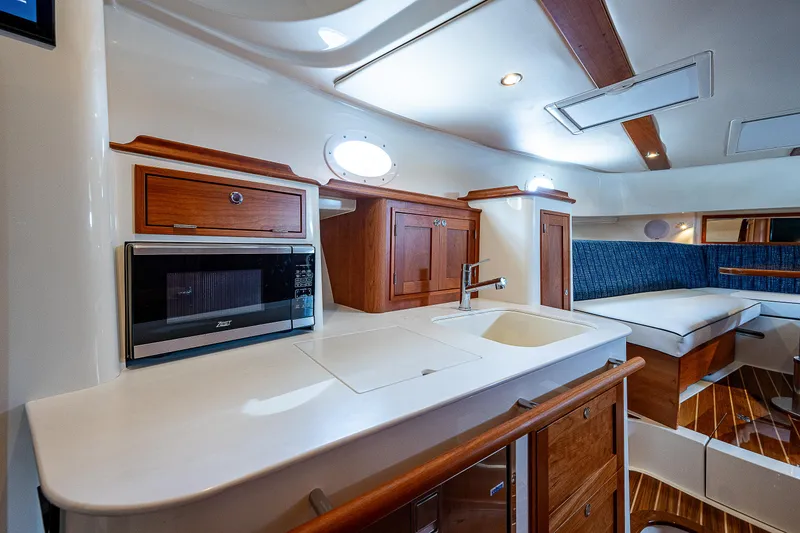 Slide: The Image of Die Innenkabine der Hinckley Sport Boat 40 X von 2023 zeigt eine elegante Küche mit Holzschränken. - 20