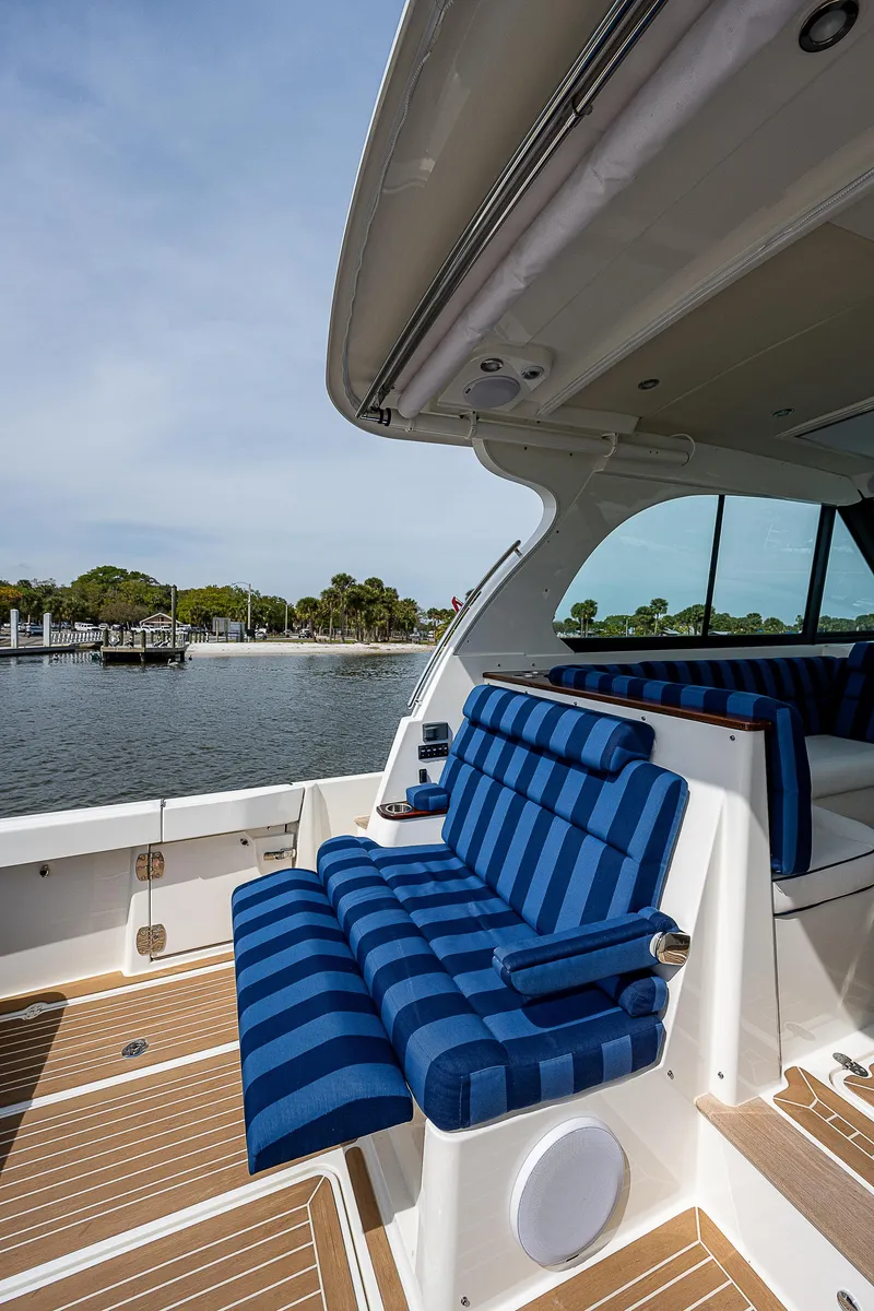 Slide: The Image of Hinckley Sport Boat 40 X von 2023 mit gestreiften blauen Sitzen und Holzboden am Wasser. - 9