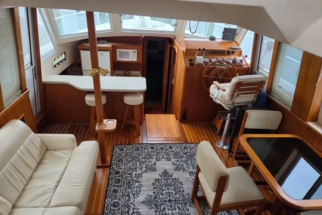 Slide: The Image of Interior of 2002 Mainship 430 Trawler with cozy seating and nautical decor. - 5