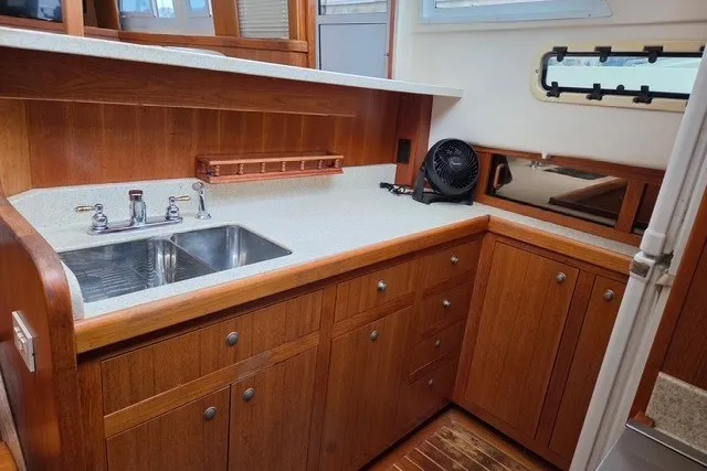 Slide: The Image of 2002 Mainship 430 Trawler kitchen with wooden cabinets and stainless steel sink. - 8
