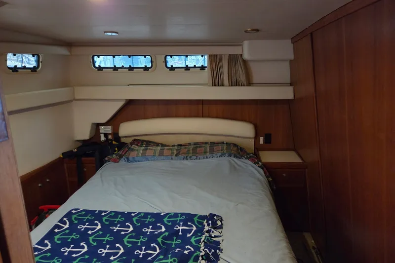Slide: The Image of Cozy cabin interior of 2002 Mainship 430 Trawler with bed and wooden paneling. - 15