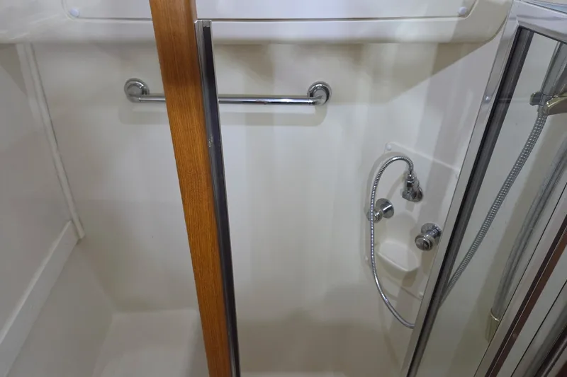 Slide: The Image of Shower area in 2002 Mainship 430 Trawler with chrome fixtures and wooden accents. - 20