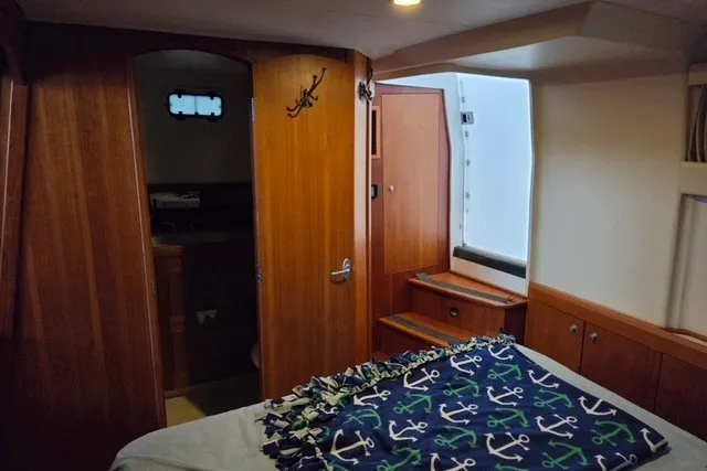 Slide: The Image of Cozy cabin interior of 2002 Mainship 430 Trawler with nautical-themed bedding. - 16