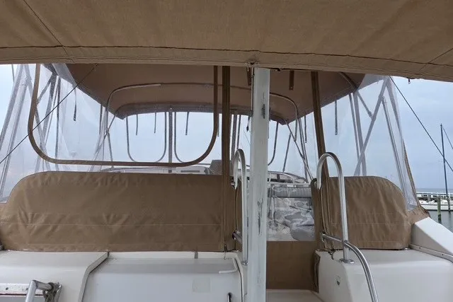 Slide: The Image of 2002 Mainship 430 Trawler with beige canopy and clear panels at marina. - 4
