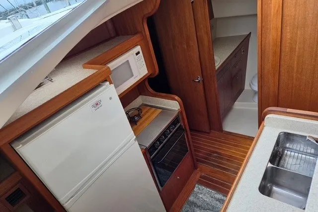 Slide: The Image of Interior of 2002 Mainship 430 Trawler with kitchen appliances and wooden cabinetry. - 10