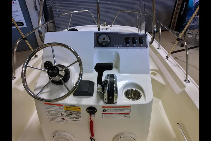 Slide: The Image of 2027 Boston Whaler 150 Montauk boat console with steering wheel and controls. - 6
