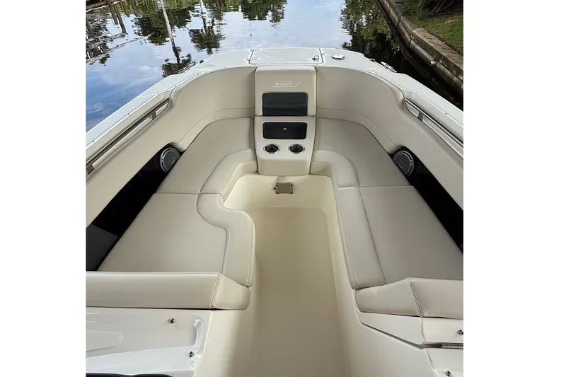 Slide: The Image of 2019 Boston Whaler 270 Vantage boat interior with cushioned seating and cup holders. - 12