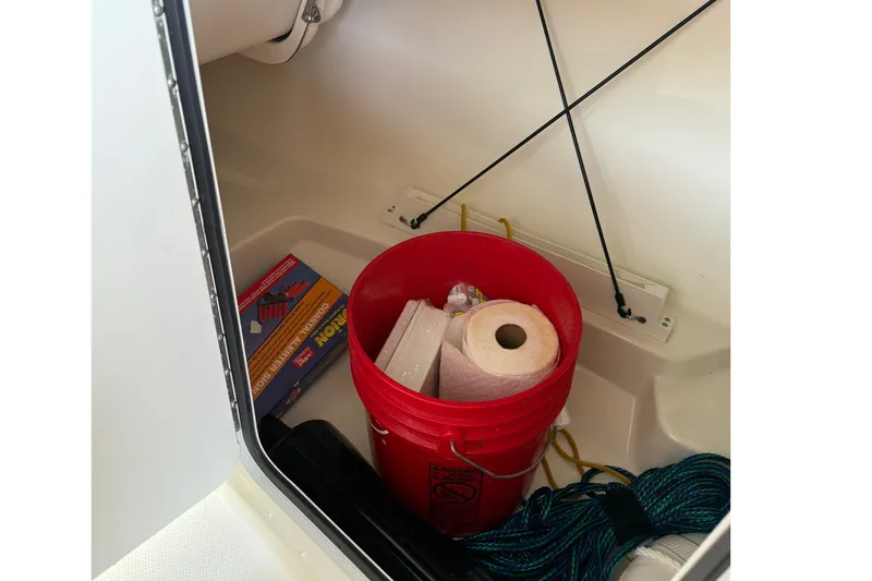 Slide: The Image of Storage compartment in a 2019 Boston Whaler 270 Vantage with bucket and supplies. - 32