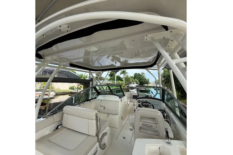 Slide: The Image of 2019 Boston Whaler 270 Vantage boat interior with seating and helm, docked by a canal. - 21