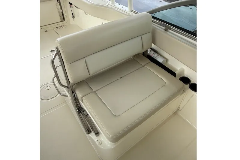Slide: The Image of 2019 Boston Whaler 270 Vantage boat seat with beige upholstery and cup holders. - 18