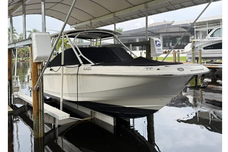 The Image of 2019 Boston Whaler 270 Vantage boat docked under a canopy. - 0