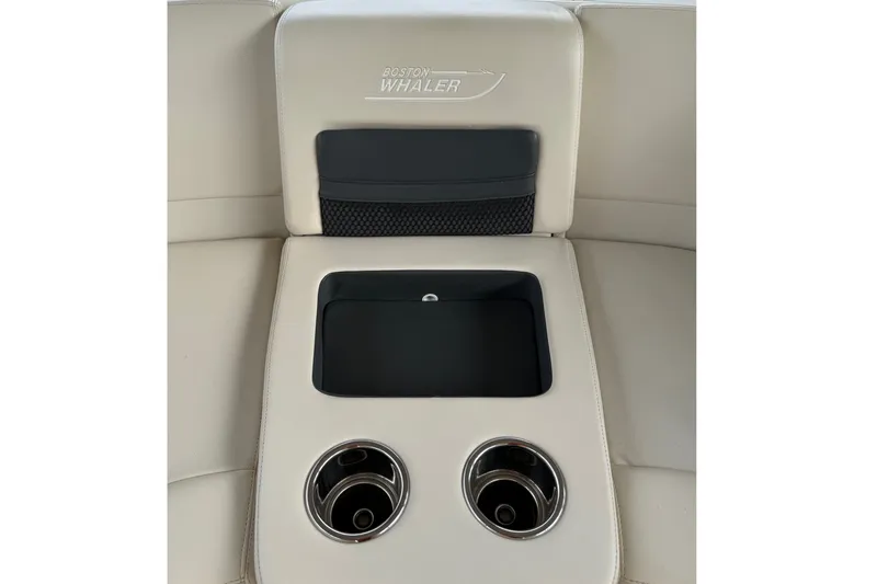 Slide: The Image of 2019 Boston Whaler 270 Vantage boat interior with cup holders and storage compartment. - 14