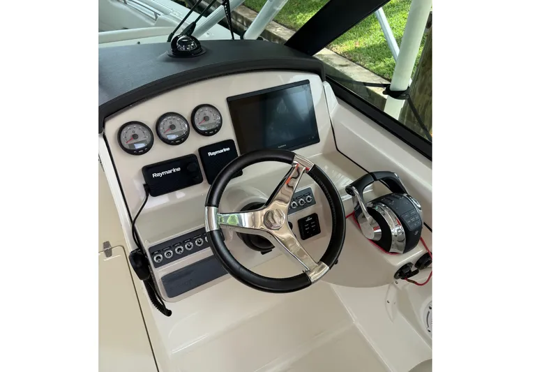 Slide: The Image of 2019 Boston Whaler 270 Vantage helm with steering wheel, gauges, and Raymarine electronics. - 11