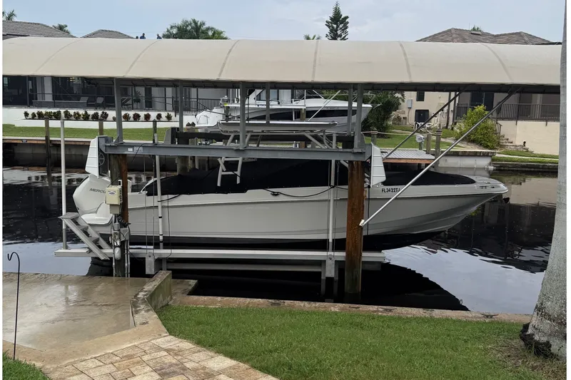 Slide: The Image of 2019 Boston Whaler 270 Vantage boat docked under a canopy in a residential canal. - 1