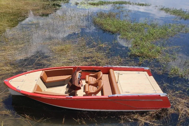 Slide: The Image of Red 2007 Frauscher 686 Lido boat on calm water with lush greenery. - 0