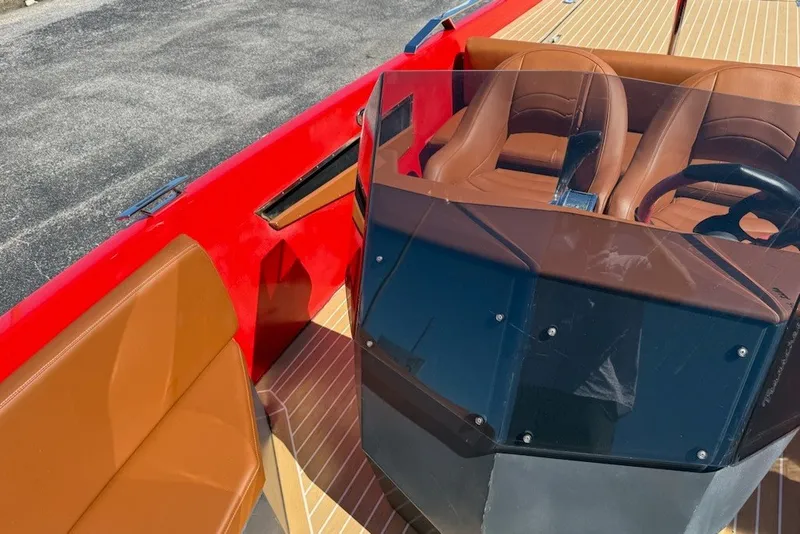 Slide: The Image of 2007 Frauscher 686 Lido boat interior with red exterior, brown seats, and steering wheel. - 8