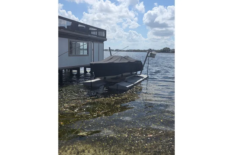 Slide: The Image of Covered 2007 Frauscher 686 Lido boat docked by a lakeside house. - 27