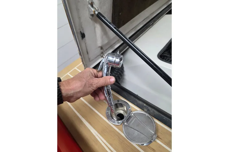 Slide: The Image of Hand holding a chrome showerhead on a 2007 Frauscher 686 Lido boat deck. - 26