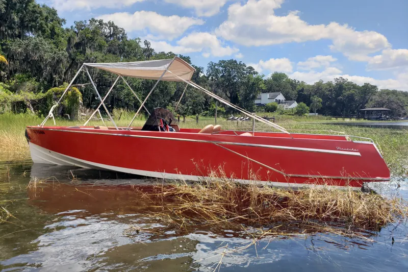 The Image of Red 2007 Frauscher 686 Lido boat with canopy, docked in a scenic lakeside setting. - 1