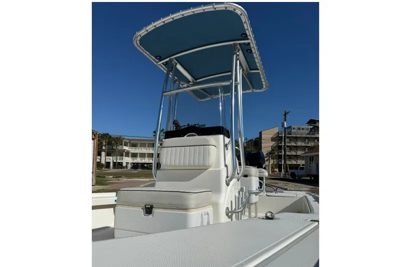 Slide: The Image of 2015 Mako 21 LTS boat with T-top and seating, under clear blue sky. - 11