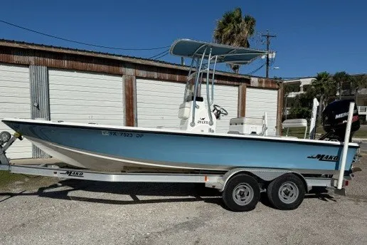 Slide: The Image of 2015 Mako 21 LTS boat on trailer, parked outdoors near a garage. - 3