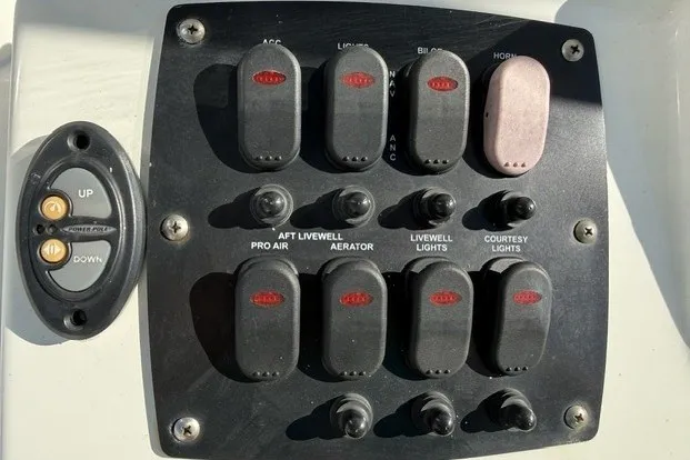 Slide: The Image of Control panel of a 2015 Mako 21 LTS boat with various switches and buttons. - 6