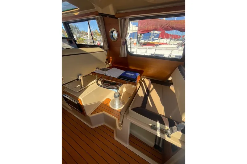 Slide: The Image of Interior of 2018 Ranger Tug R-27 with wooden table and seating area. - 10