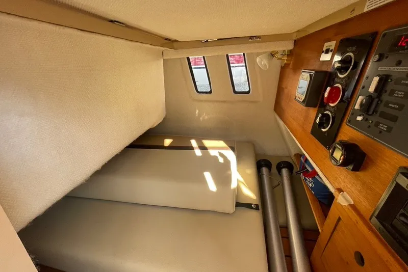Slide: The Image of 2018 Ranger Tug R-27 cabin interior with control panel and cozy sleeping area. - 26