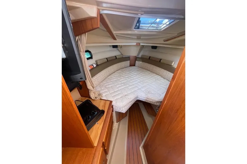 Slide: The Image of 2018 Ranger Tug R-27 cabin interior with bed, wood accents, and skylight. - 19
