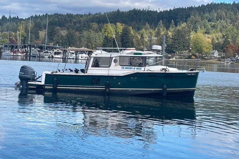 Slide: The Image of 2018 Ranger Tug R-27 boat on a calm lake with forested background. - 1