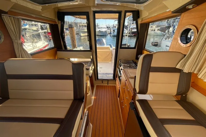 Slide: The Image of Interior of a 2018 Ranger Tug R-27 boat with seating and kitchenette. - 25