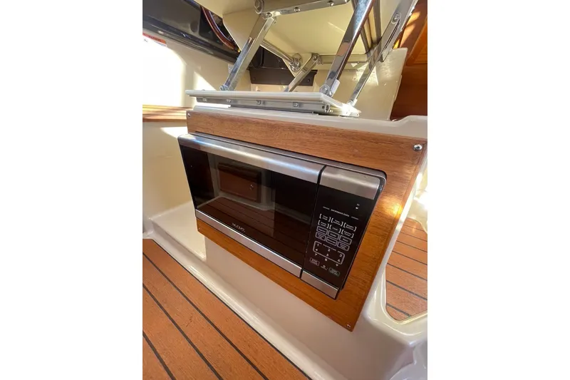Slide: The Image of 2018 Ranger Tug R-27 interior with built-in microwave and wood paneling. - 15