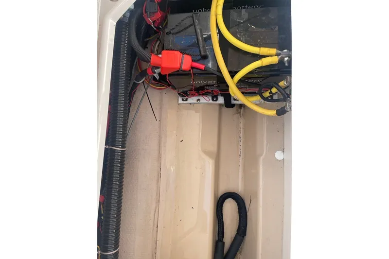 Slide: The Image of Battery compartment of a 2018 Ranger Tug R-27 with visible wiring and cables. - 32