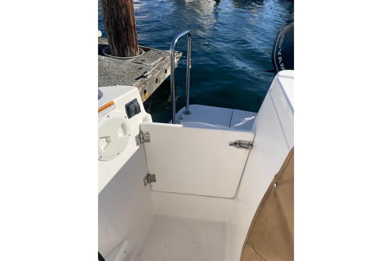 Slide: The Image of 2018 Ranger Tug R-27 boat stern view with open gate and dockside water. - 8
