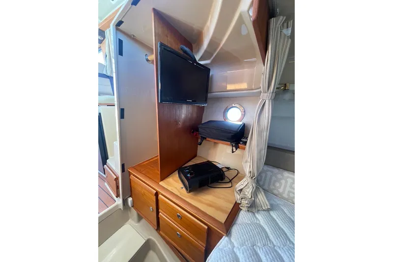 Slide: The Image of 2018 Ranger Tug R-27 cabin interior with TV, drawers, and porthole. - 24