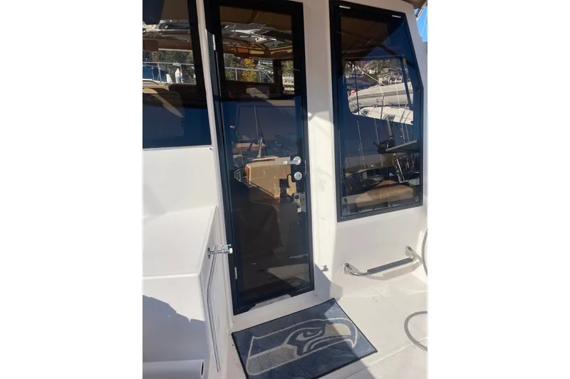 Slide: The Image of 2018 Ranger Tug R-27 boat entrance with glass door and Seattle Seahawks mat. - 6
