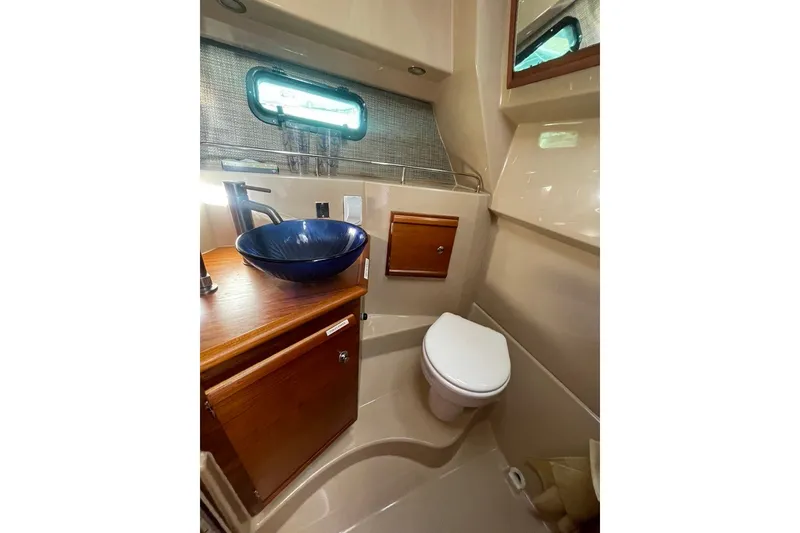 Slide: The Image of 2018 Ranger Tug R-27 bathroom with modern sink, toilet, and wooden cabinetry. - 22