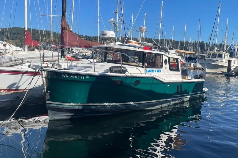 Slide: The Image of 2018 Ranger Tug R-27 boat docked in a marina with sailboats. - 2