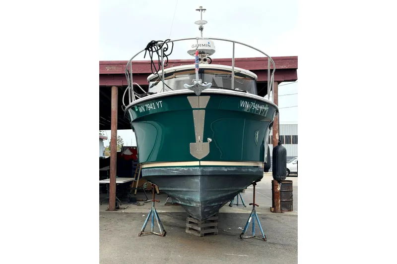 Slide: The Image of 2018 Ranger Tug R-27 boat on stands, front view in a marina setting. - 43
