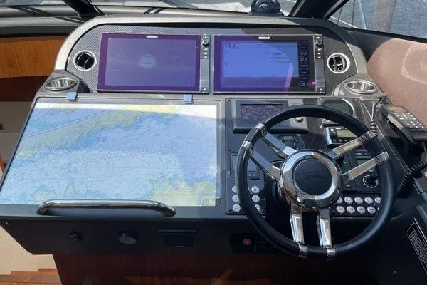 Slide: The Image of Control panel of 2016 Sunseeker Predator 57 yacht with navigation screens and steering wheel. - 23
