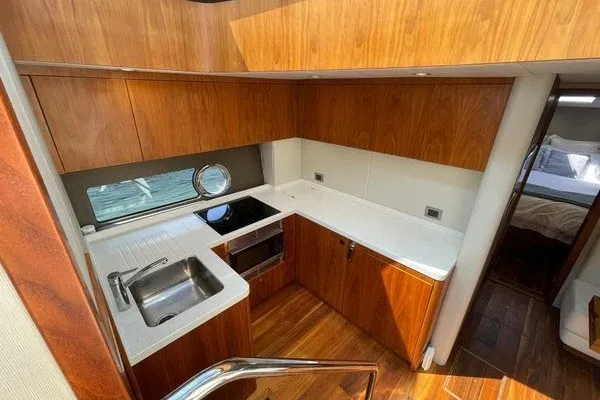 Slide: The Image of Luxurious 2016 Sunseeker Predator 57 yacht kitchen with modern wood cabinetry and sleek appliances. - 28