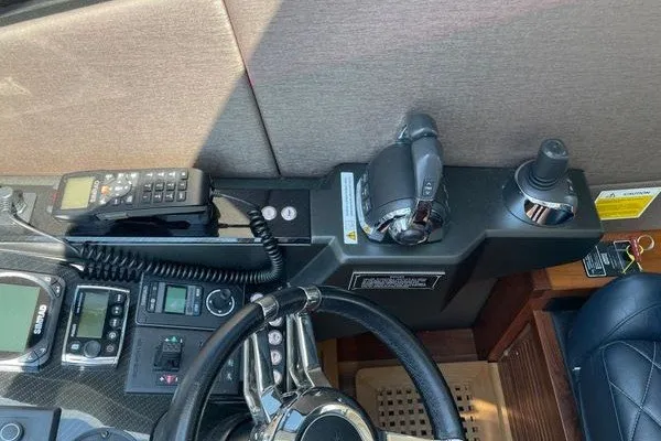 Slide: The Image of Cockpit controls of a 2016 Sunseeker Predator 57 yacht, featuring steering wheel and navigation equipment. - 25