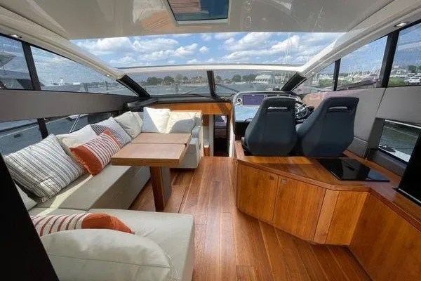 Slide: The Image of Luxurious interior of a 2016 Sunseeker Predator 57 yacht with plush seating and wooden flooring. - 14