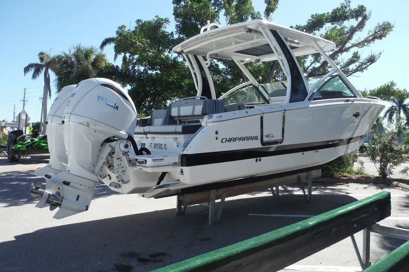 Slide: The Image of 2025 Chaparral 310 OSX boat with Yamaha engines, displayed outdoors in a sunny setting. - 21