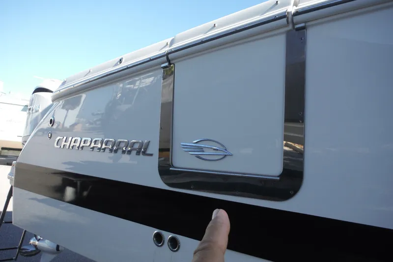 Slide: The Image of 2025 Chaparral 310 OSX boat exterior with logo and sleek design. - 67