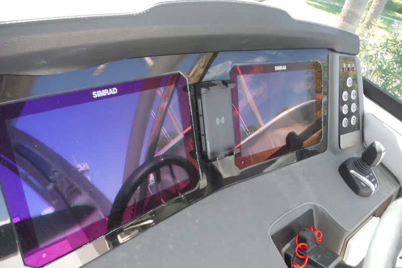 Slide: The Image of Dashboard of 2025 Chaparral 310 OSX with dual Simrad displays and joystick control. - 47