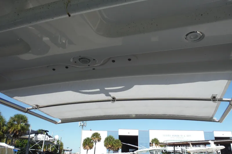 Slide: The Image of 2025 Chaparral 310 OSX boat canopy with clear sky and palm trees in background. - 48