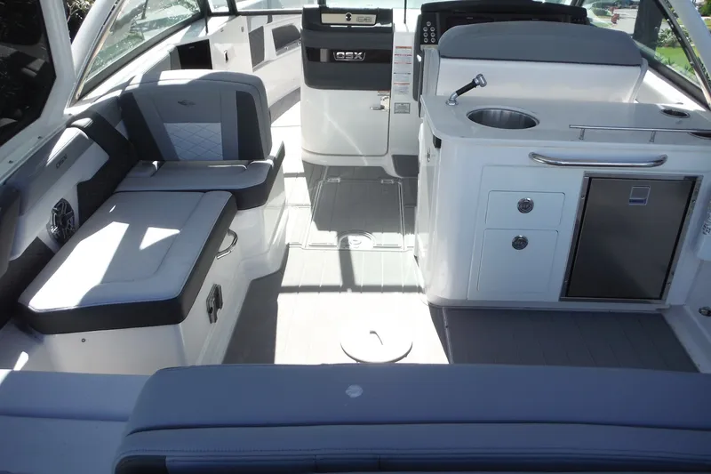 Slide: The Image of Interior of 2025 Chaparral 310 OSX boat, featuring seating and kitchenette area. - 29