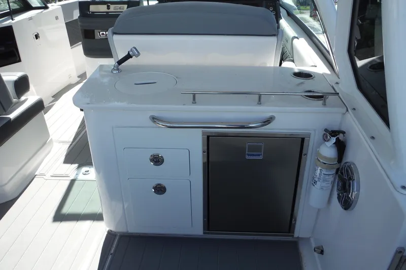 Slide: The Image of 2025 Chaparral 310 OSX boat interior with kitchenette and storage features. - 37